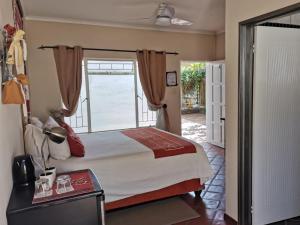 - une chambre avec un grand lit et une fenêtre dans l'établissement Londiningi GuestHouse, à Windhoek