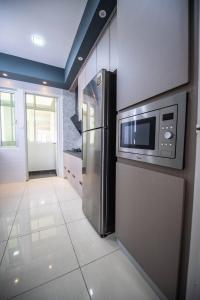 a kitchen with a refrigerator and a microwave at De Luma # The Rumah--BM CITY in Bukit Mertajam