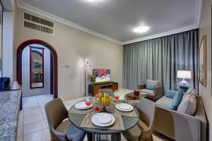 a living room with a dining table and a couch at Al Nakheel Hotel Apartments Abu Dhabi in Abu Dhabi