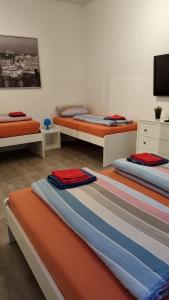 um quarto com 3 camas e uma televisão de ecrã plano em Stadtnah an der Förde 75 em Flensburg