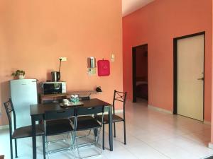 a dining room with a table and a refrigerator at Homestay Tok Penghulu in Kuantan