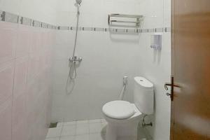 een witte badkamer met een toilet en een douche bij Mahkota Residence Mitra RedDoorz in Karawang