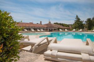 a swimming pool with lounge chairs and a house at Hotel Nibaru in Porto Cervo