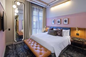 um quarto com uma cama grande e um espelho em voco Johannesburg Rosebank an IHG Hotel em Joanesburgo