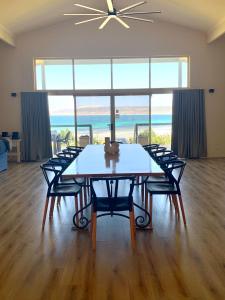 a dining room with a table and chairs with a view of the ocean at Emu Bay Lodge in Emu Bay