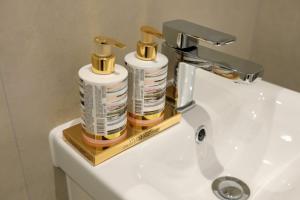 ein Waschbecken mit zwei Flaschen Duftspender darauf in der Unterkunft Aisiki Apartments at Stanhope Road, North Finchley, Airconditioned 3-Bedroom and 2-Bathroom, Pet-Friendly Duplex Flat, King or Twin Beds, with Free Wi-Fi in Finchley + 35 Fotos