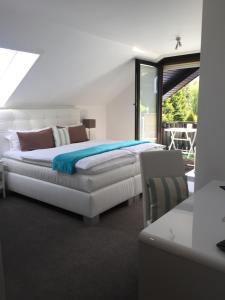 a white bedroom with a bed and a balcony at Gästehaus Cramer in Bad Kissingen