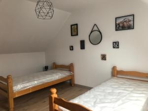 2 Betten in einem Zimmer mit Bildern an der Wand in der Unterkunft Maison chaleureuse à la campagne in Camps-en-Amiénois