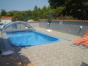 a blue swimming pool with a cover on a patio at Apartmani Kristiana in Jezera
