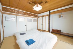 a bedroom with a white bed with a blue towel on it at Maple Farm in Asahikawa