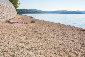 a rocky beach next to a body of water at Apartmani Kristiana in Jezera
