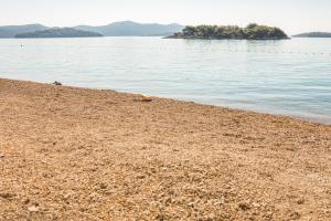 a sandy beach next to a body of water at Apartmani Kristiana in Jezera