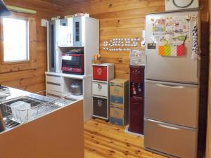 a kitchen with a refrigerator and some boxes at Holiday Home Fu in Nakijin