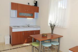 a kitchen with a table and chairs and a sink at Apartmani Kristiana in Jezera