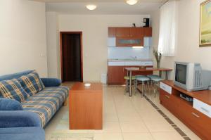 a living room with a couch and a kitchen at Apartmani Kristiana in Jezera