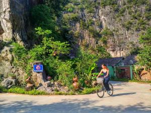 a woman riding a bike down a street at Tam Coc Nature in Ninh Binh