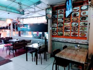 a restaurant with tables and chairs and plates on the wall at Living Room Guesthouse & Cafe Bar in Karon Beach