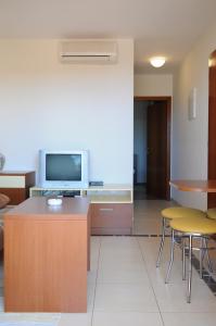 a living room with a tv and a table and chairs at Apartmani Kristiana in Jezera