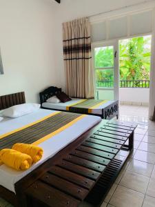 two beds in a room with a window at Sethway Village in Minneriya