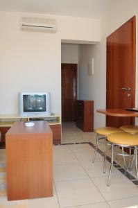 a waiting room with a tv and a table and chairs at Apartmani Kristiana in Jezera
