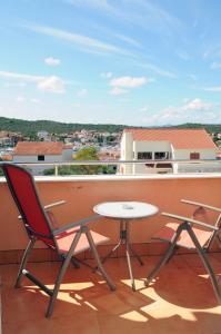 a balcony with a table and chairs on a roof at Apartmani Kristiana in Jezera