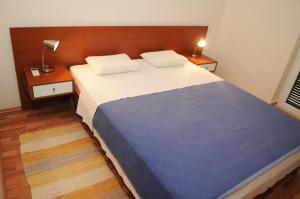 a bedroom with a large bed with two pillows at Apartmani Kristiana in Jezera