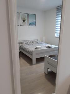 a bedroom with a bed and a mirror at Elena apartmani Tuzla in Tuzla