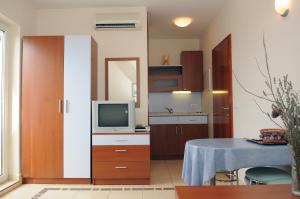 a small kitchen with a table and a television at Apartmani Kristiana in Jezera