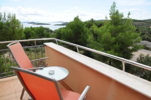 a balcony with a table and chairs and a view of the water at Apartmani Kristiana in Jezera