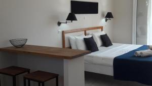 1 dormitorio con cama y mesa con vistas a las faldas en Toni´s Guesthouse, en Kavos