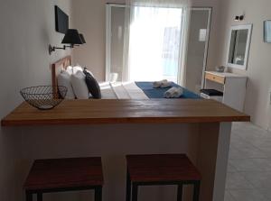 una camera con un letto e un bancone con due sgabelli di Toni´s Guesthouse a Kávos