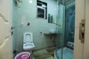 a small bathroom with a toilet and a shower at Villa Residency in Navi Mumbai