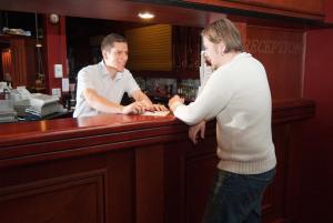 dos hombres parados en un mostrador en un bar en Hotel Kiteenhovi, en Kitee