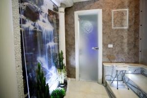 bagno con vasca e finestra con piante di Leone Camere D'autore - CHIAIA a Napoli Altre 37 foto