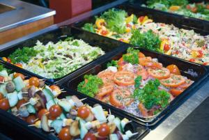 a buffet line with trays of different types of food at Hotel Kiteenhovi in Kitee