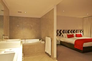 a hotel room with a bed and a tub and a bed and a bed at Zero Davey Boutique Apartment Hotel in Hobart