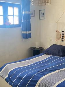 a bedroom with a bed with blue and white stripes at Appartement de 2 chambres avec vue sur la ville piscine partagee et jardin clos a Gaillac in Gaillac