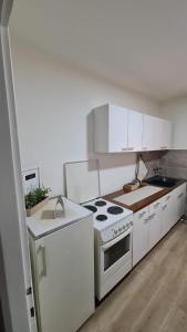 a kitchen with white cabinets and a stove top oven at Apartman Pavlovic in Leskovac