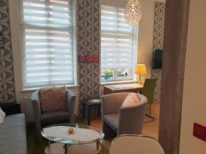 - un salon avec des chaises, une table et des fenêtres dans l'établissement Ferienwohnung, à Halle-sur-Saale