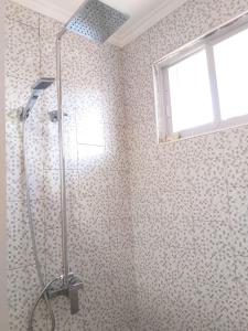 a shower stall in a bathroom with a window at Bernis Hostel in Moalboal