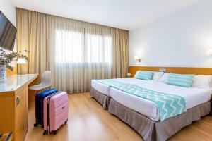 a hotel room with a bed and a suitcase at Daniya Alicante in Alicante