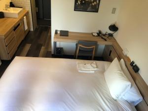 a hotel room with a bed and a desk at Hotel Cordia Osaka in Osaka
