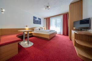 um quarto de hotel com uma cama e uma televisão de ecrã plano em Hotel Similaun em Vent