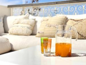 een glazen beker en twee drankjes op een tafel bij Maison Du Tresor in Marrakesh