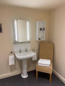 a bathroom with a sink and a chair at The Wensleydale Hotel in Middleham