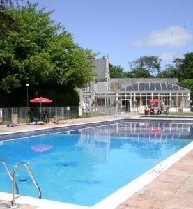 a large blue swimming pool in front of a building at Atlantic Reach Cottages, Newquay 6 miles, 2 Bedrooms in Newquay