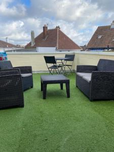 a group of chairs and a table on a patio at Logement calme et spacieux avec terrasses in Le Havre