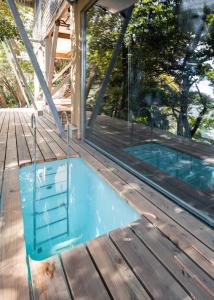 an empty swimming pool on a deck with a house at Kamakura Base in Kamakura