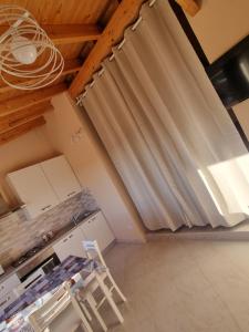 uma cozinha com persianas num quarto com uma mesa em Martina's Place (with panoramic views) em Chia