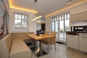 a kitchen and dining room with a table and a couch at Linden-Palais Wohnung 33 in Heiligendamm